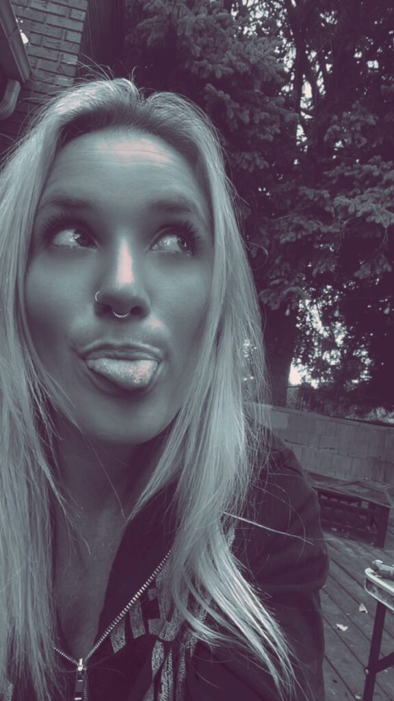 Nikyla sticking her tongue out under the trees.