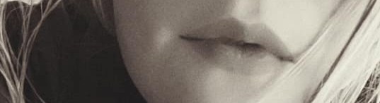 Sepia close-up of Nikyla's mouth, lips slightly parted, hair across her face.