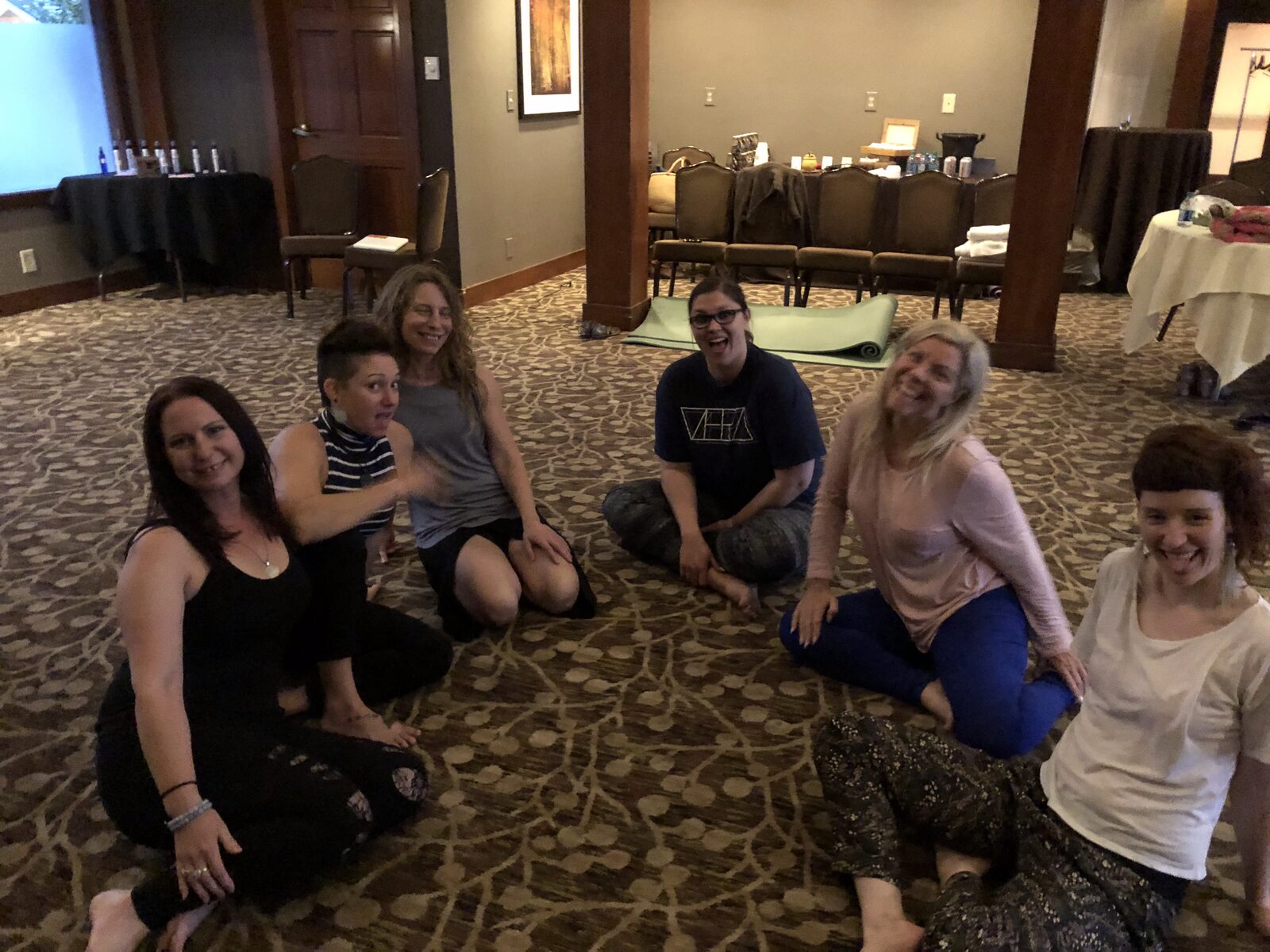 A group sitting in a circle on the floor of a meeting room.